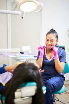 Dentist explaining to her client how to floss
