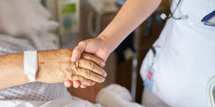 Nurse holding the hand of an older patient