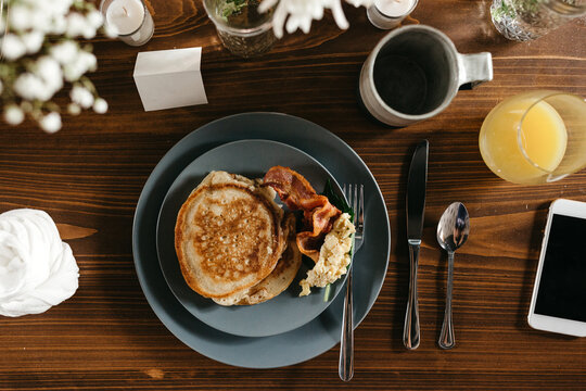 Birds eye view of a plate of breakfast with a cell phone & coffee.