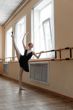 Flexible ballet dancer performing split at barre