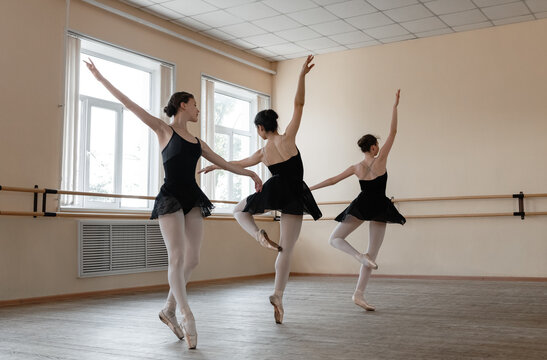 Elegant ballerinas performing graceful dance in studio