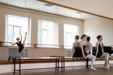Ballerinas watching friend dance in studio