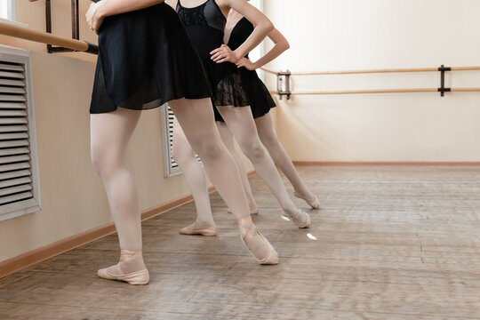 Crop ballerinas stretching leg and toes simultaneously