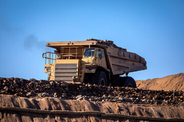 A very large haul dump truck at a construction site against a blue sky