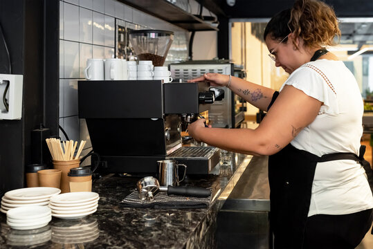 Female barista making coffee at espresso machine