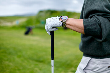 Man leaning on the golf club detail.