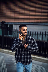 Chico joven con camisa de cuadros posando con smartphone