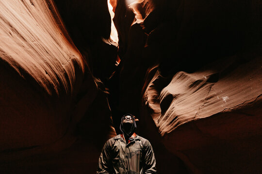A man looking up at light / sky in Antelope Canyon in Arizona