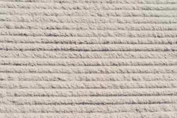 Light grey sand with horizontal rake lines