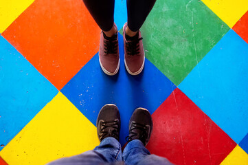 A couple stand in a Colorful floor with rhombus shape in Caminito street, Buenos Aires