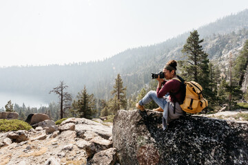 Tourist with backpack & camera hiking in mountains at Lake Tahoe in California, USA