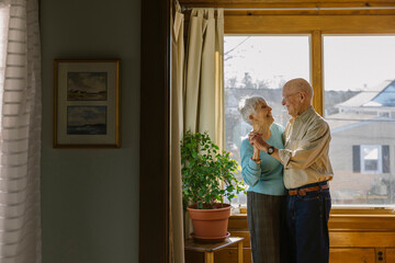 Laughing Senior Citizen Couple Hugging and Dancing