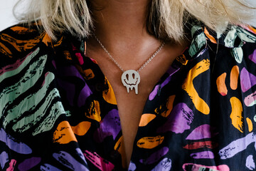 Anonymous female model with smiley necklace