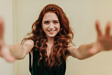 Curly red haired woman taking selfie outside