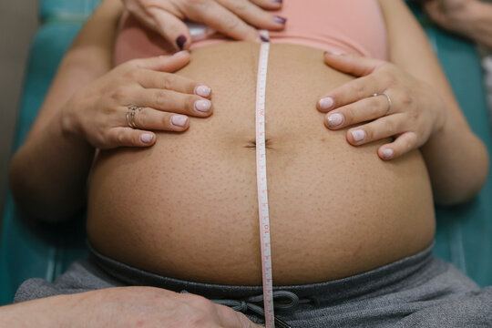 Midwife Measuring Belly of Pregant Mother