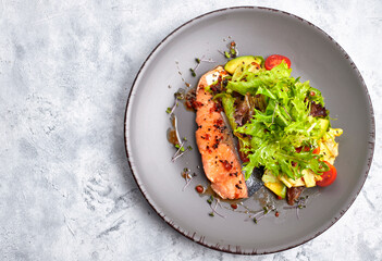 Salad with avocado and salmon, on a light background