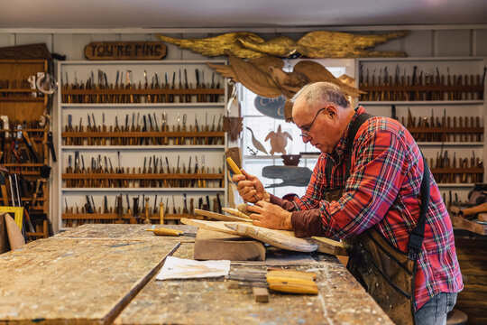 Woodworker at His workshop with wall of chisels