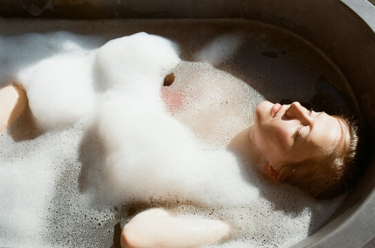 Woman relaxing in a bath with a foam