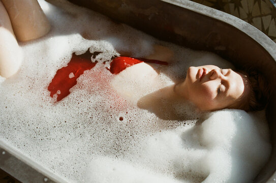 Woman relaxing in a bath with a foam
