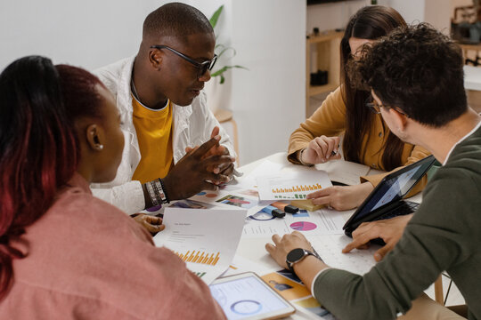 Diverse colleagues discussing charts during meeting