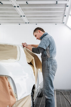 Mechanic attaching paper to vehicle window