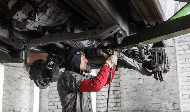 Engineer repairing bottom of car