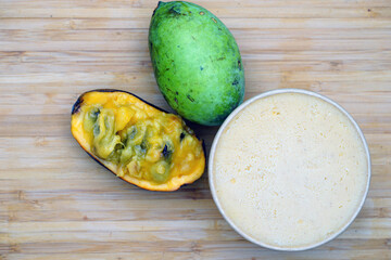 Container of spiced pawpaw sorbet with fresh pawpaw fruit