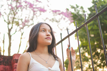 young brunette girl thinking outdoors, painted nails