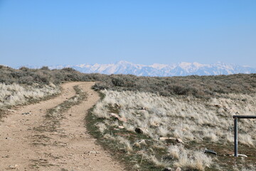 Desert like landscape and snowcapped mountains at Antelope Island State Park on the Sentry Loop trail, Utah