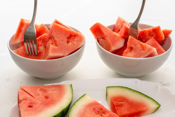 Bowl of watermelon slices on white kitchen table, fruit salad, healthy dessert