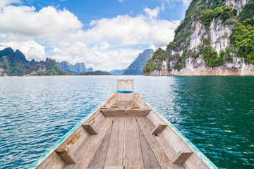 Wooden Thai traditional long-tail boat on a lake with mountains at Ratchaprapha Dam or Khao Sok National Park, Thailand
