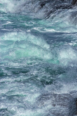 Fototapeta na wymiar Aquatic background of sea surf waves splashing close up with clear blue green water and white foam