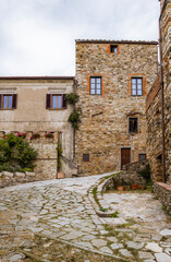 PANZANO IN CHIANTI, ITALY - OCTOBER 10, 2018: Street with winding cobbled road and medieval houses in Panzano in Chianti, Tuscany, Italy