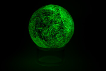 glowing green spheres fluorite on a black background looks like a planet or moon