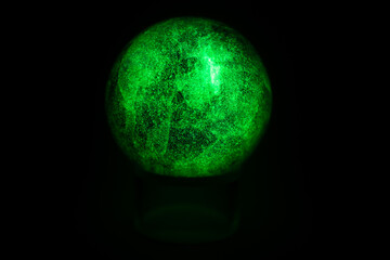 glowing green spheres fluorite on a black background looks like a planet or moon