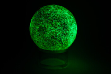 glowing green spheres fluorite on a black background looks like a planet or moon