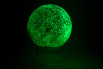glowing green spheres fluorite on a black background looks like a planet or moon