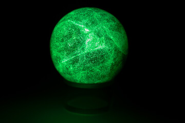 glowing green spheres fluorite on a black background looks like a planet or moon