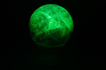 glowing green spheres fluorite on a black background looks like a planet or moon