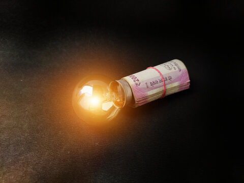Financial innovation idea, creative solutions depicted by glowing light bulb and money bank notes