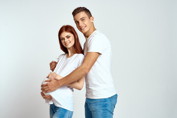 a pregnant woman and a young man are waiting for a baby on a light background emotions family love