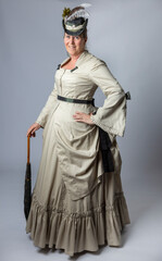 A middle-aged woman in a Victorian costume holding a parasol