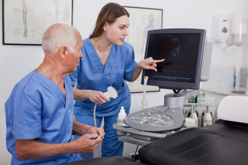 Obraz premium Skilled and experience sonographer showing and explaining a new equipment to assistant
