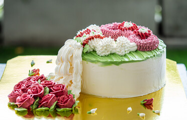 The cake is decorated with a garland of roses made from creamer. Beautiful to eat and delivered as...