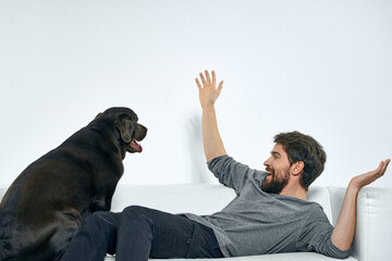 Man with a pet dog on the couch fun friends emotions light room
