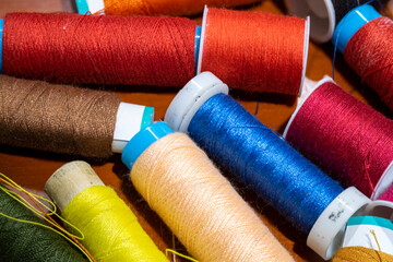 close up of stacked spools of different colored sewing thread