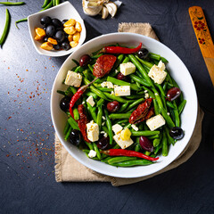 Spicy green bean salad with olives, feta cheese and dried tomatoes