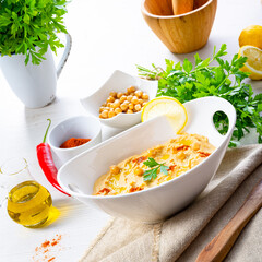 hummus paste with lemon and chilli on white background