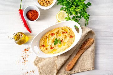 hummus paste with lemon and chilli on white background