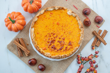 slice of home made pumpkin pie on plate with pumpkins